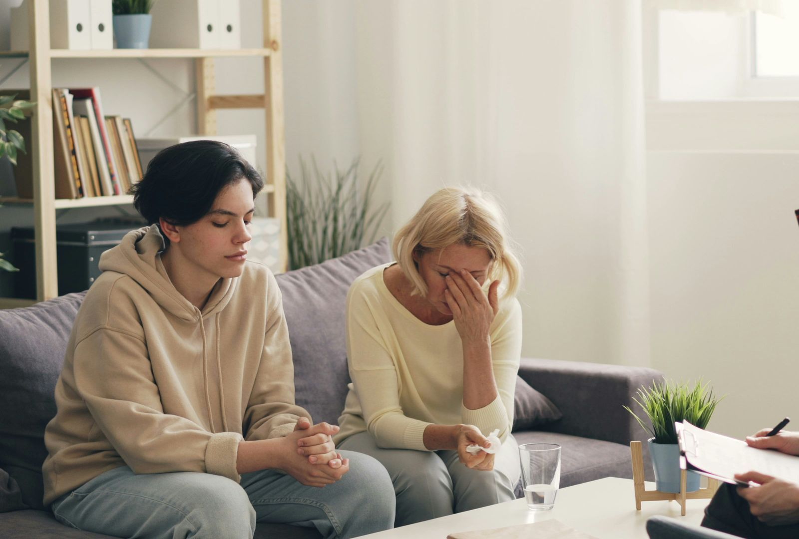 two women sitting on a couch talking to each other